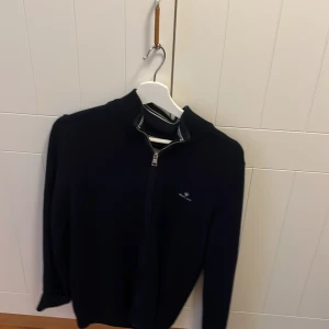 Mörkblå tröja med dragkedja - Säljer en stilren mörkblå tröja med dragkedja och långärmad design. Perfekt för kyligare dagar och enkel att matcha med olika outfits.