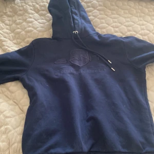 Mörkblå Hoodie från Gant - Säljer en mörkblå hoodie från Gant. Nästan aldrig använd och är nästan i nyskick.