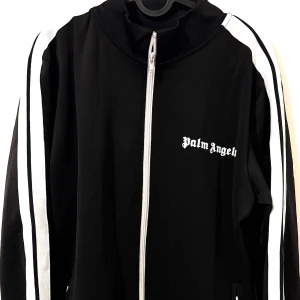 Zip-Up Jacket | Palm Angles - Stilren zip-up jacket från Palm Angels med ikoniska detaljer. Perfekt balans mellan lyx och streetwear. Helt ny, aldrig använd och med lappar kvar. Riktig statement-piece! (FÖRST TILL KVARN)