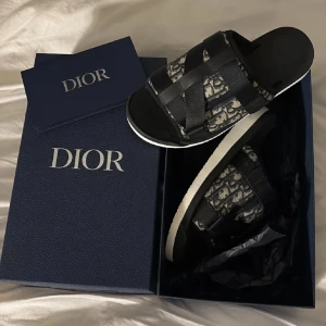 Dior slides  - Säljer ett par feta slides från dior. Sjukt bra skick då det nästan alldrig är använda perfekta nu inför sommaren självklart hör av dig för funderingar och fler frågor 