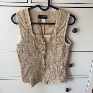 Beige ärmlös topp från Peruvian Perfection - Säljer en beige ärmlös topp från Peruvian Perfection i 100% bomull. Perfekt för varma dagar!