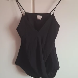 Svart linnetopp med smala band - Säljer en svart linnetopp med smala justerbara band. 