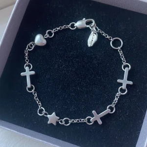Silverarmband med kors och stjärna - Snyggt silverarmband med detaljer som kors, stjärna och hjärta. Perfekt för att ge en snygg touch till din outfit! 