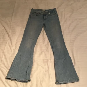 Ljusblå bootcut jeans från 157 - Ljusblå jeans från 157 i modellen bootcut med låg midja. Jeansen har klassisk femficksdesign, knapp och dragkedja framtill samt raka ben som blir vidare nedtill. Perfekta för dig som gillar retrostil.