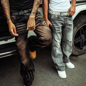 Gråsvarta baggy jeans med slitningar och tryck - Säljer ett par gråsvarta jeans med baggy passform och tydliga slitningar. Lukamachain jeans aldrig använda, då dom var för små för mig