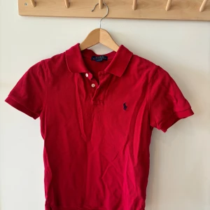 Röd pikétröja från Polo Ralph Lauren - Superfint skick! Pikétröjan är i storlek M barn / 10-12år. Köpt från kids brand store för 995kr.