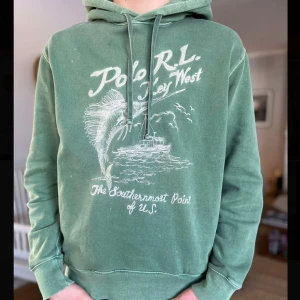 Ralph Lauren Hoodie - Säljer en grön hoodie från Ralph Lauren. Hoodien har en klassisk passform med justerbar huva och ribbade muddar vid ärmslut och nederkant. Perfekt för en avslappnad stil. Hör bara av dig vid någon fråga