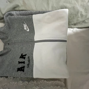 Grå och vit zip-hoodie från Nike x AIK - Säljer en grå och vit hoodie med dragkedja från Nike i samarbete med AIK. Jackan har broderad AIK Stockholm-logga på bröstet och klassisk Nike-logga. Perfekt för dig som vill ha en sportig och stilren look. Nypris 1400kr