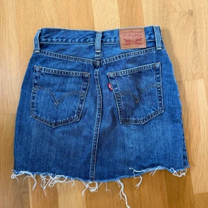 Levi’s jeanskjol  - Levi’s jeanskjol med hög midja och slitningar nertill💙stl, W24. Produkten är knappt använd, därav i ny skick! 😇Ny pris 499kr
