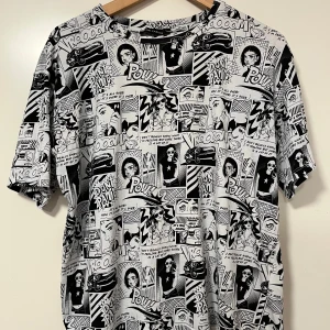 Svartvit t-shirt med serietidningsmönster från LCW Casual - Cool svartvit t-shirt från LCW Casual med serietidningsinspirerat tryck över hela plagget. T-shirten har normal passform och korta ärmar. Perfekt för dig som gillar unika och grafiska prints.