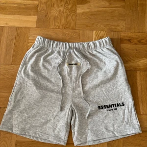Grå shorts från Essentials - Snygga ljusgrå shorts från Essentials som är helt nya. De har elastisk midja med snörning och en bakficka. Pris går att diskutera så skriv