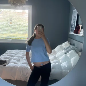 Ljusblå croppad t-shirt - Säljer en ljusblå croppad t-shirt med korta ärmar. Enkel och stilren design, perfekt till jeans eller shorts. Skön och lätt att bära under varma dagar.