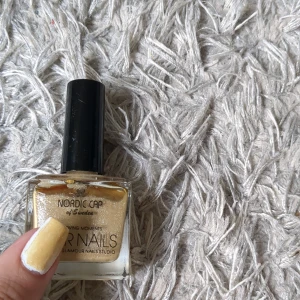 Guldigt nagellack från STARNAILS  - Nagellack i en skimrande guldig nyans från Nordic Cap. Kommer i en fyrkantig glasflaska med svart kork. Perfekt för att ge naglarna en glittrig och elegant look. På bilden ser ni färgen över mitt vita nagellack☺️