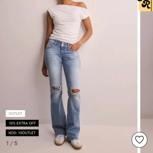 nelly jeans - Säljer ett par ljusblå bootcut jeans med slitna knän och klassisk femficksdesign från nelly. De är endast andvända en gång då jag inte gillade dom💞