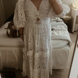 Vit långklänning - Superfin vit långklänning med broderade blommor och trekvarts puffärmar. Djup v-ringning framtill och knytning i ryggen. Klänningen har volangdetaljer och är perfekt för midsommar eller mösspåtagning💞💞Den är helt oanvänd med prislappen kvar! Skriv privat för mer bilder☺️