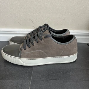 Lanvin skor - Säljer ett par stilrena grå sneakers från Lanvin. Storleken är 43 och skicket är 9/10. Sko låda och dust bag tillkommer tyvärr inte. Vid funderingar är det bara att skriva!