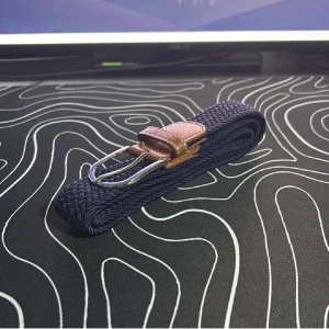 Mörkblått flätat bälte med bruna skinn-detaljer - Snyggt mörkblått flätat bälte med detaljer i brunt skinn och silverspänne. Bältet har en klassisk design och passar perfekt till jeans eller chinos. Flätad struktur gör det enkelt att justera längden efter behov. Helt ny från butik 