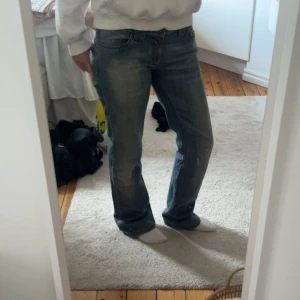 Blå jeansbyxor med straight fit - Säljer ett par klassiska blå jeansbyxor med rak passform. Jeansen har normal midja, fem fickor och snygga slitningar för en avslappnad look. Perfekta till vardags och lätta att matcha med olika stilar.
