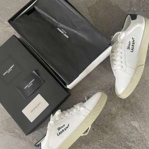 Saint Laurent skor - Säljer ett par vita Saint Laurent sneakers i nyskick🌤️ perfekt nu till sommaren för en fräsch stilren outfit🤩pris kan diskuteras vid snabb affär 💨