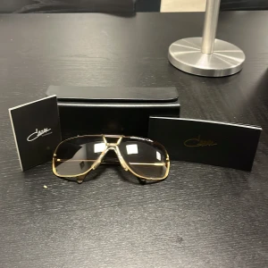 Cazal Targa 902 solglasögon i guld - Exklusiva Cazal Targa 902 solglasögon med guldfärgad metallram och bruna tonade linser. Äkta o nya, fick som present o blev skockad för hur mycket det kostar men jag använder inte de så de har inget värde. Nypris 2500kr, ja säljer 1500kr, priset ligger inte på Sten så hör av er för frågor!!