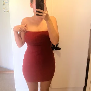 Röd ribbad tubklänning - Säljer en tight, röd ribbad tubklänning. Klänningen är kort och ärmlös.