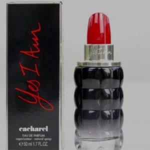 Cacharel Yes I Am parfym 50ml - Cacharel Yes I Am Eau de Parfum i en cool flaska som ser ut som ett läppstift. Flaskan är svart och silver med en röd topp, och rymmer 50 ml. Perfekt för dig som gillar unika och snygga parfymflaskor.