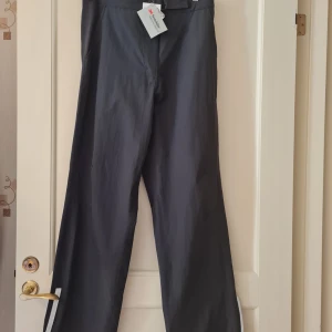 Walking-byxor för dam från 3M Scotchlite strl 40 - Svarta byxor walking-byxor från 3M Scotchlite. Byxorna har elastisk midja och är tillverkade i ett syntetmaterial som passar bra för utomhusaktiviteter. Storlek 40.