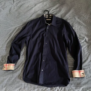 Burberry Skjorta - Säljer denna riktigt feta eftertraktade Burberry skjorta i färgen marinblå! 🙌 Storleken är medium men passar även small, nypris ligger på ungefär 3500kr, mitt pris = 729kr! ⭐️ Helt perfekt nu på sommaren, hör av er vid minsta fråga eller fundering! 🙌