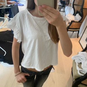 Vit volangtopp med kort ärm - Supersöt vit topp från Zara med volangdetaljer på ärmarna. 