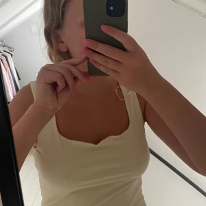 Ljusgul linnetopp från Gina Tricot - Säljer en ljusgul linnetopp från Gina Tricot, Elevated Basics. Toppen har en fyrkantig ringning och är ärmlös med en enkel, clean look. Perfekt att styla med jeans eller kjol för en fräsch vibe.