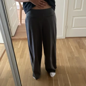 Grå wide byxor från Zara - Säljer ett par gråa wide byxor från Zara i storlek 164. Byxorna har hög midja, raka vida ben och diskreta fickor framtill. Sköna och stilrena, perfekta för en chill och snygg look.