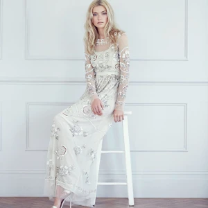Needle & Thread klänning med paljetter - Ny pris ca 7000 sek. Drömmig långklänning i ljus champagnefärg med transparent mesh och broderade blommor i silver och pärlemor. Klänningen har långa ärmar, rund halsringning och är täckt av paljetter och pärlor som ger en magisk glittrig effekt. Perfekt för dig som vill sticka ut.