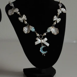 Pärlhalsband med rosett och måne - Jag skapar handgjorda smycken och om du köper dem blir du unik, eftersom smyckena är helt unika😍