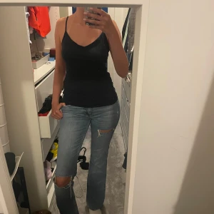 Ljusblå bootcut jeans med slitningar - Säljer ett par ljusblå jeans med bootcut passform och snygga slitningar vid knäna. Jag är 177 för längdreferens
