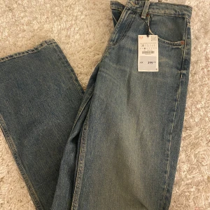 Wide leg jeans från Zara, blå - Säljer ett par blå wide leg jeans från Zara i storlek 36. Klassisk femficksmodell med mellan hög midja och raka, vida ben. Jeansen har snygg tvättad look och är tillverkade i bomull. Perfekta för en chill och trendig stil.