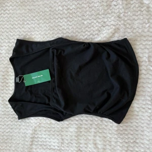 Svart och vit linnetopp från SHEIN - Två stilrena linnetoppar från SHEIN i svart och vitt. Modellen är ärmlös med rund halsringning och lätt rynkade sidor nedtill för en snygg passform. Perfekta att matcha med jeans eller kjol. Tillverkade i mjuk bomull för maximal komfort.