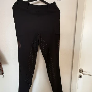 Svarta leggings - Snygga svarta leggins. Byxorna har bälteshällor, fickor på sidorna och en tight passform som sitter skönt. Perfekta för dig som vill ha stil och funktion i gymmet eller i vardag. Nypris 1000 kr 