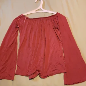 offshoulder topp från Cotton On - Säljer en snygg offshoulder topp från Cotton On i storlek XXS. Toppen har långa, vida ärmar och en lös passform med resår upptill som håller den på plats. Perfekt för dig som gillar en avslappnad men trendig stil.