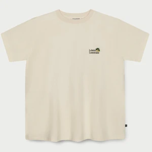 Pippi Långstrump t-shirt Lobster & Lemonade - Beige t-shirt från Lobster & Lemonade med liten broderad logga framtill och stor färgglad Pippi Långstrump-illustration på ryggen. Klassisk passform, rund hals och korta ärmar. Tillverkad i mjuk bomull, perfekt för dig som gillar unika prints och retrovibbar.