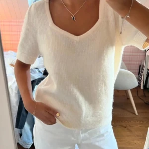 &otherstories tröja - Säljer en stilren vit ribbad topp med korta ärmar och v-ringning. Perfekt för en avslappnad och chic look. Passar bra till både jeans och kjol. från other stories super fin 🥰