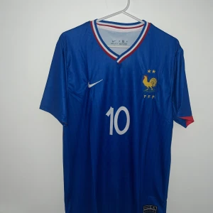  Mbappe Frankrike 2025 hemmatröja  - Mbappe Frankrike 2025 hemmatröja, tröjan är helt nytt och oanvänd. Den passar för Strolek L och M. 