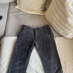 Grå manchesterbyxor från Hampton Republic - Snygga grå manchesterbyxor från Hampton Republic i slim fit. Byxorna har en klassisk design med knappar och dragkedja framtill. Perfekta för en stilren look.