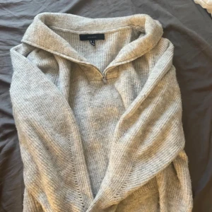 Grå stickad tröja från Vero Moda - Mysig grà stickad troja frn Vero Moda med dragkedja och hög krage. Perfekt för kyliga dagar med sin mjuka och bekväma passform. En stilren och enkel design som passar till det mesta. Jag är vanligtvis en S och den här sitter bra. Passar perfekt till våren och sena sommarkvällar 💛