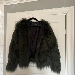 Mörkgrön pälsjacka från ONLY - Säljer en snygg mörkgrön pälsjacka från ONLY. Jackan har en fluffig och lyxig look med långa ärmar.