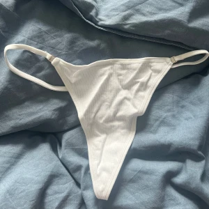Vit ribbad stringtrosor helt nya - Snygg vit ribbad underdel med söt hjärtformad detalj baktill. Helt nya och oanvända 