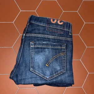 Mörkblå jeans från Dondup - Snygga mörkblå jeans från Dondup med klassisk femficksdesign och knappgylf. Jeansen har en stilren look och kontrastsömmar. Perfekta för en avslappnad stil. Skriv gärna om frågor och priser kan alltid förhandlas!🤩