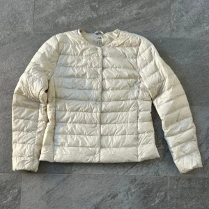jacka från Uniqlo - Säljer en superlätt beige dunjacka från Uniqlo. Jackan har en stilren design med långa ärmar och är perfekt till våren. Den är tillverkad i ett lätt och smidigt material som gör den enkel att bära med sig. Perfekt för lager-på-lager-stil! Säljer för det är lite för liten💗💗