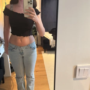 Svart croppad topp från H&M - Säljer en supersnygg svart croppad topp från H&M. Kan stylas på olika sätt beroende på hur man vill ha den som visas på bild 2 & 3. Storlek xs. 