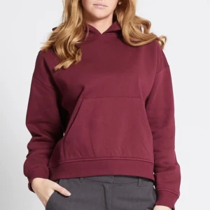 Vinröd hoodie - Säljer en stilren vinröd hoodie med en stor ficka framtill och en bekväm huva. Perfekt för kyliga dagar och ger en avslappnad look. Passar bra till både jeans och mjukisbyxor.