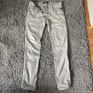 Grå jeansbyxor från Replay - Snygga grå jeansbyxor från Replay, modell Anbass. De har en klassisk femficksdesign och en bekväm passform. Perfekta för en stilren look. Näst intill helt nya, inga defekter.